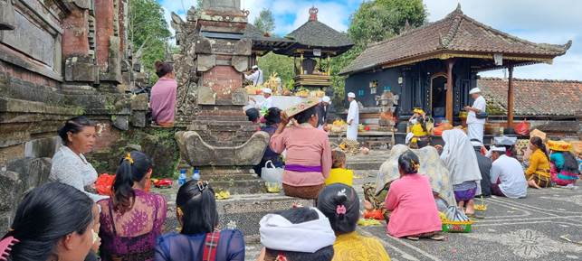 Cerimonia religiosa con fedeli in abiti tradizionali in un tempio di Bali